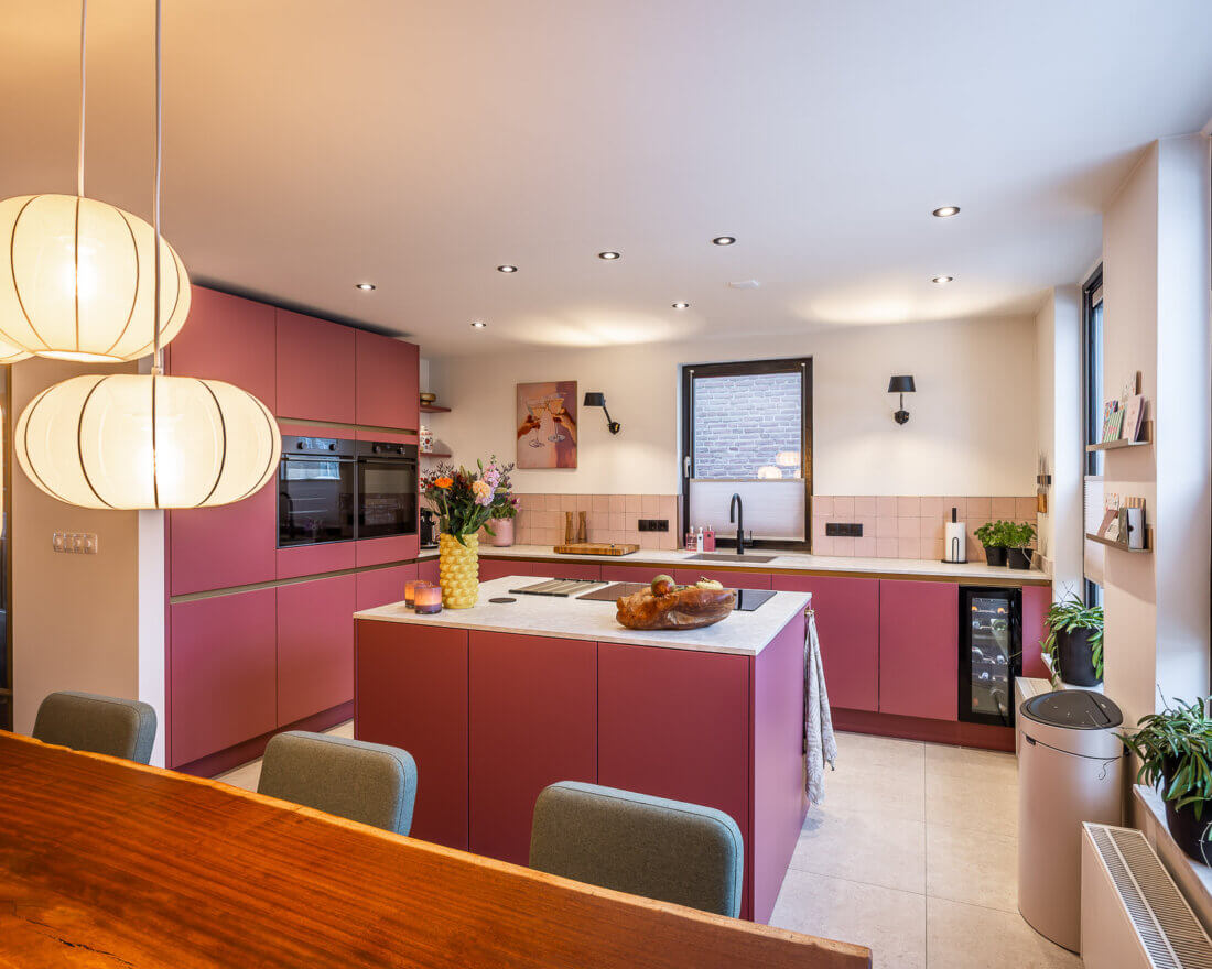 roze L vormige keuken met kookeiland