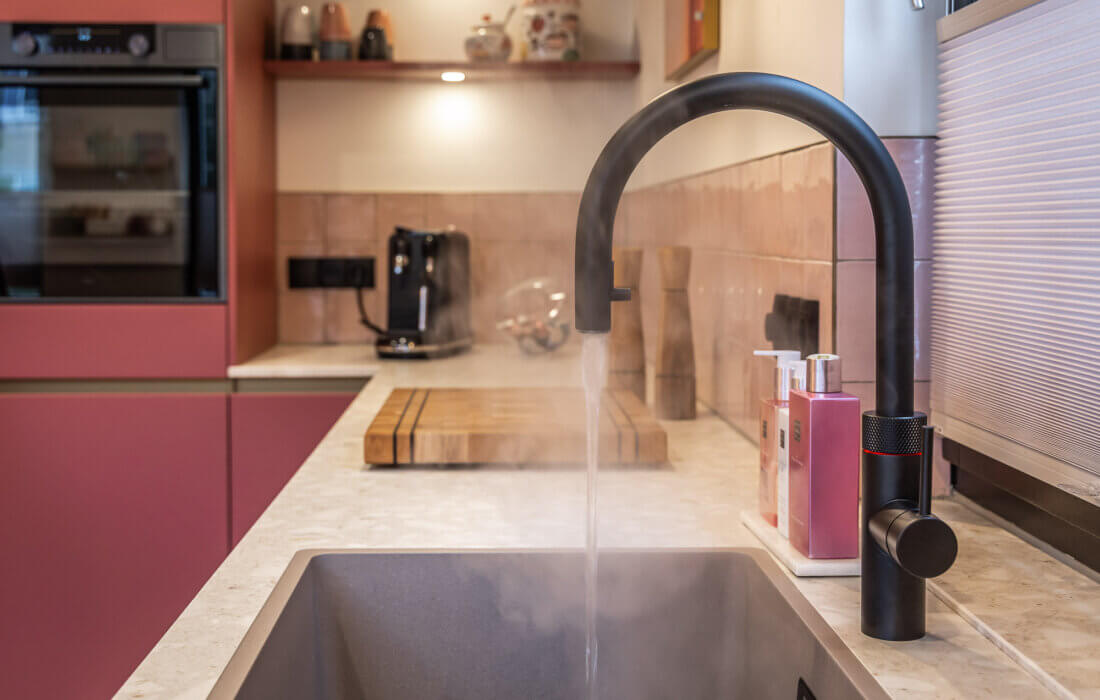 Mat zwarte Quooker kraan in roze keuken