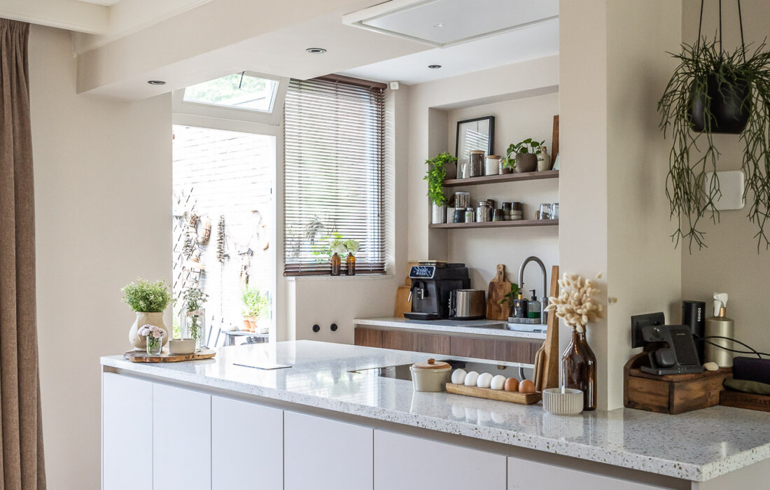 open keuken met beige schiereiland met zwevend werkblad van composiet