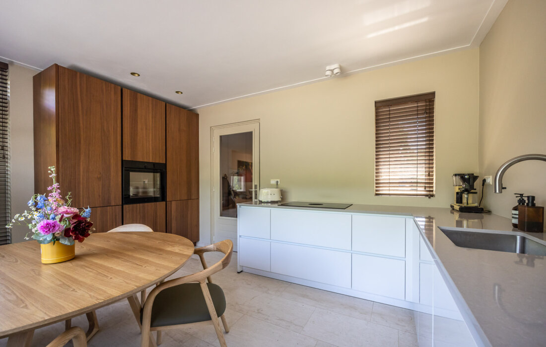 moderne hooglans witte keuken met houten kastenwand