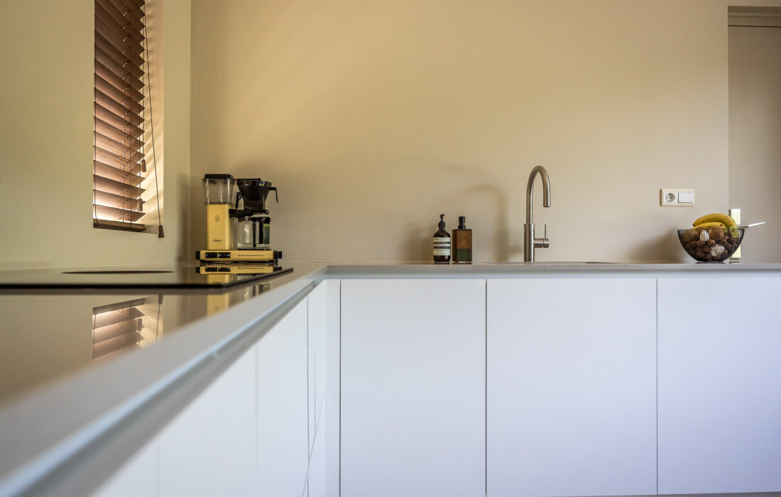 witte moderne en greeploze keuken